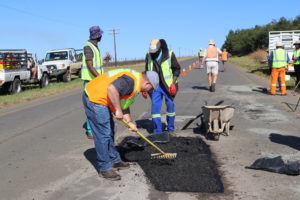 Volunteers work together to fill potholes.